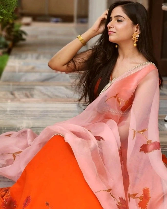 Woman wearing a traditional outfit with a pink and orange saree.