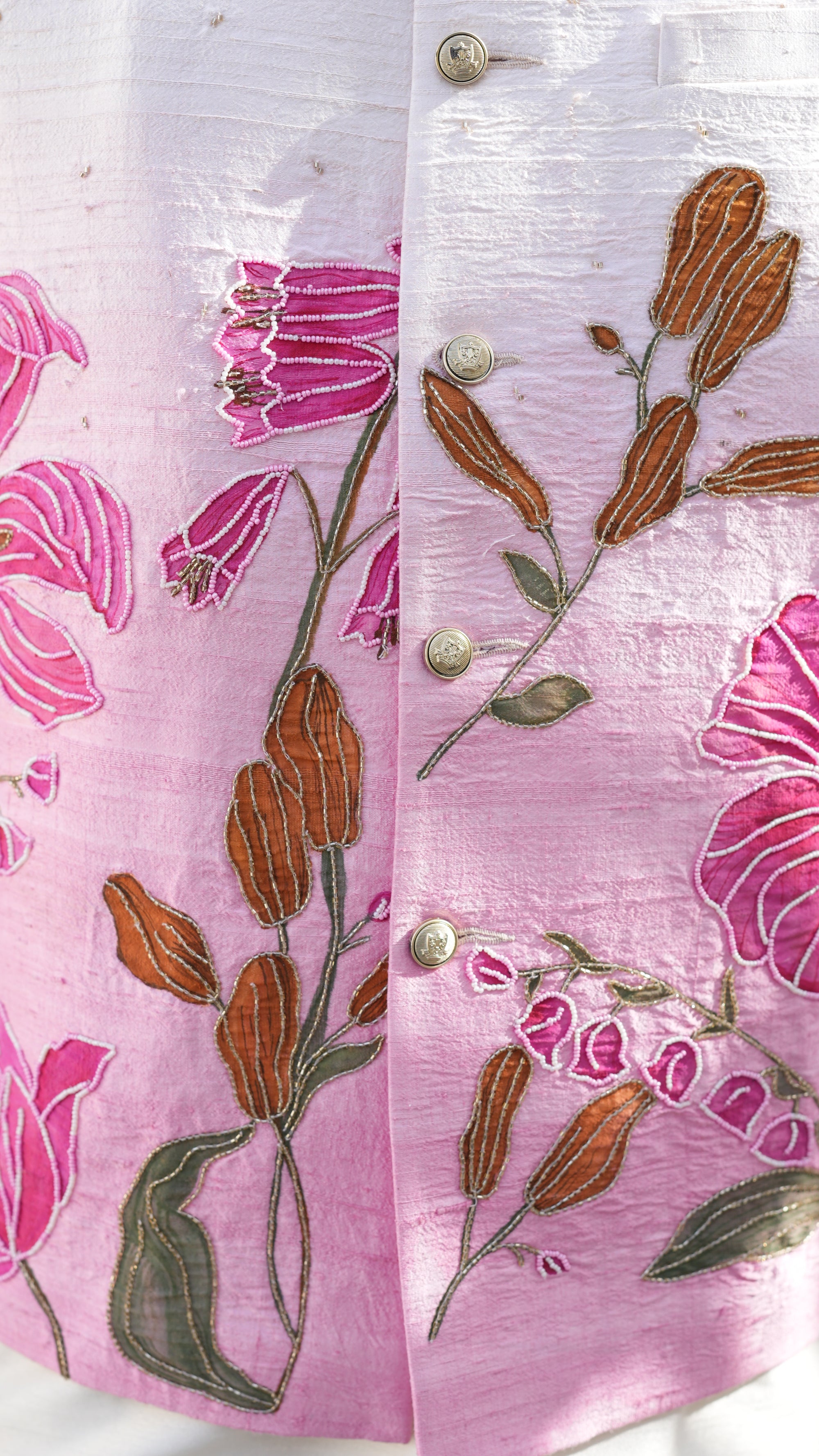 Pink fabric hand painte with floral embroidery on a white background