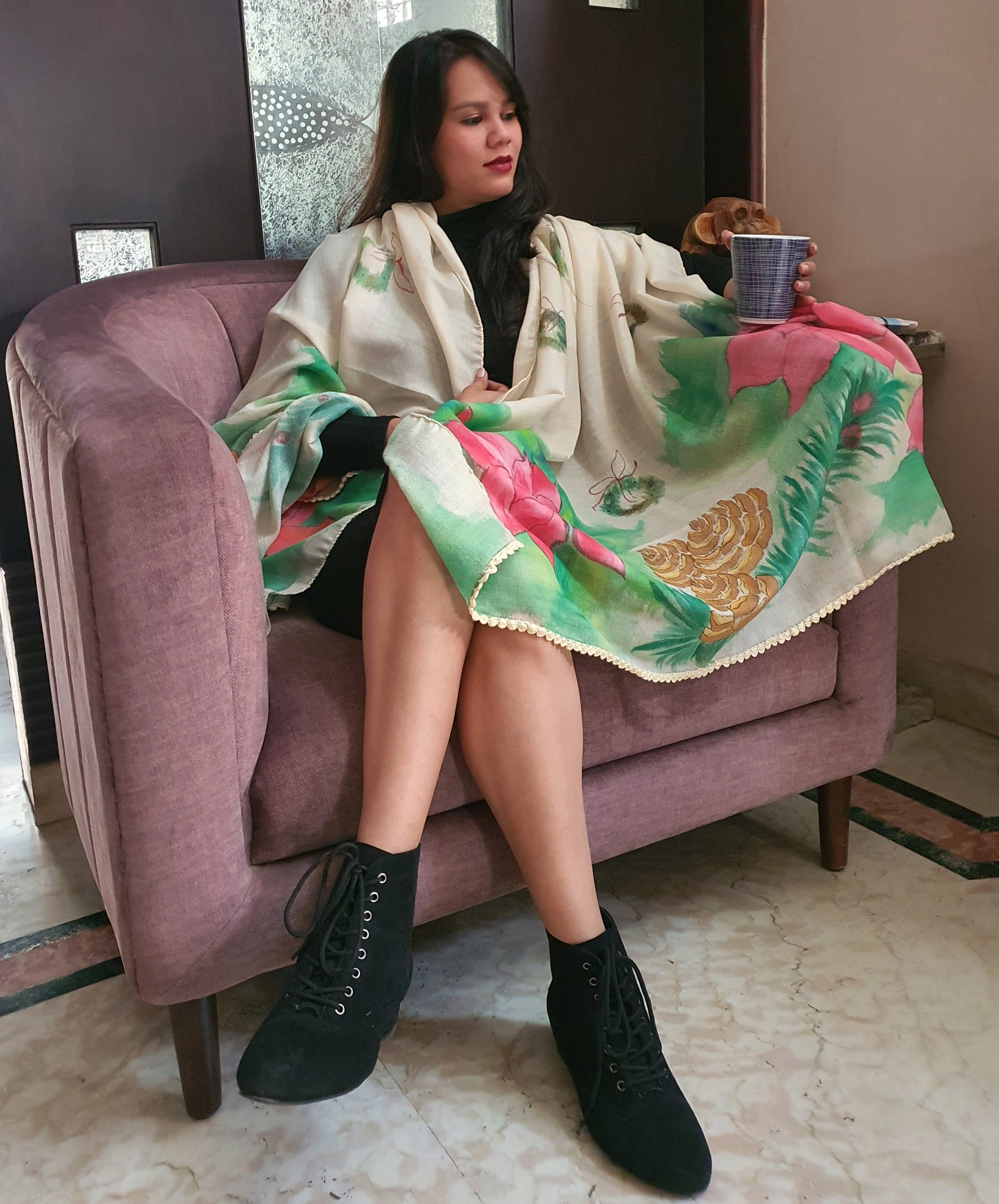 Woman sitting on a couch with a colorful hand painted stole draped over her.