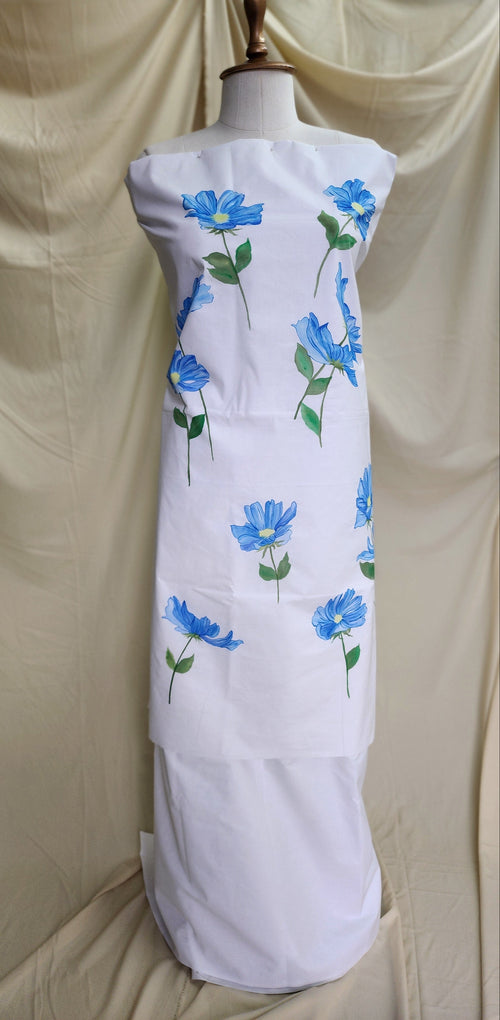 White suit set with blue floral patterns on a mannequin against a beige background