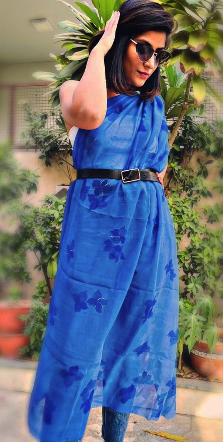 Woman wearing a blue hand painted floral stole in a garden setting