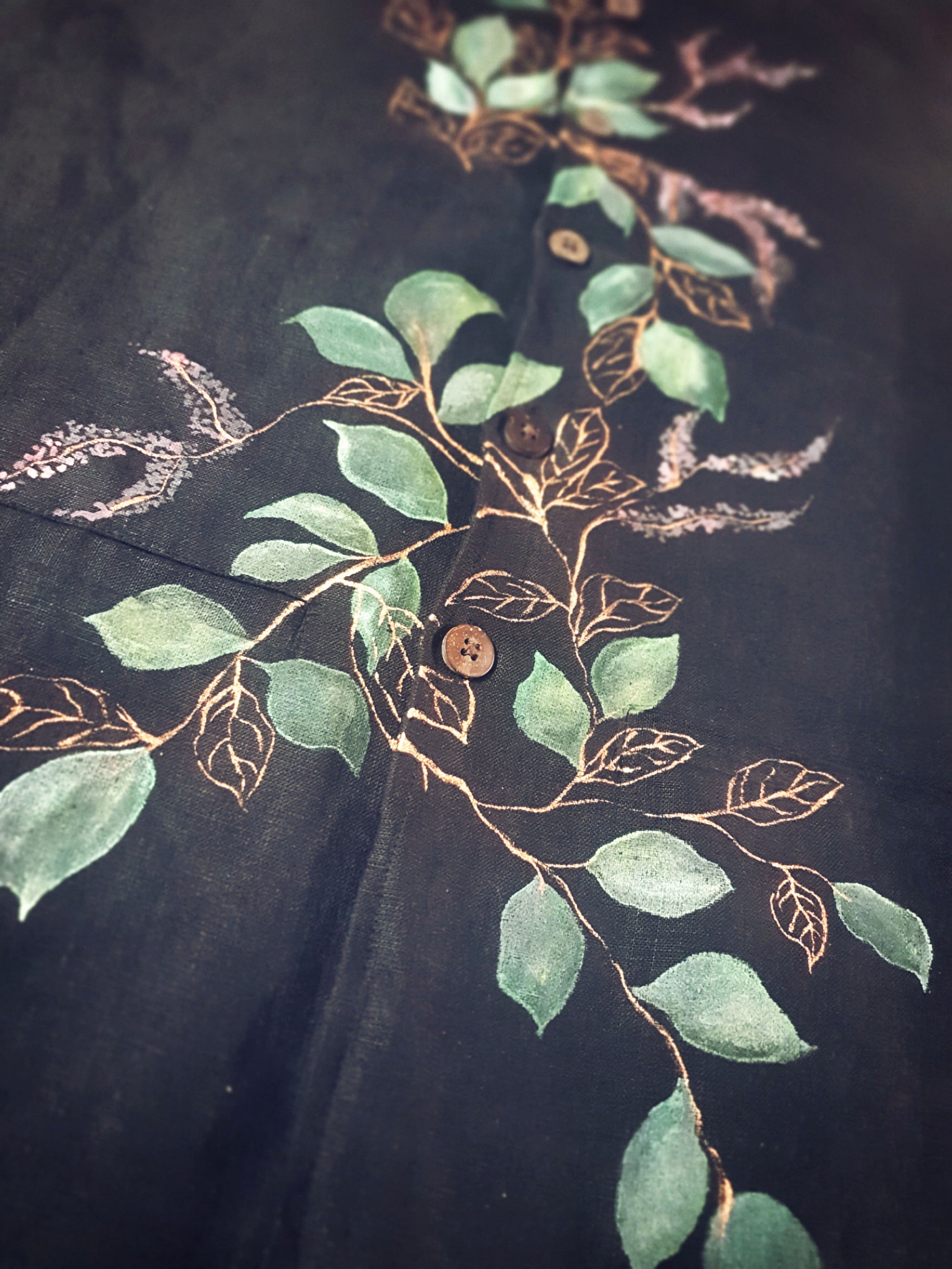 Hand Painted design of leaves and branches on a dark fabric background