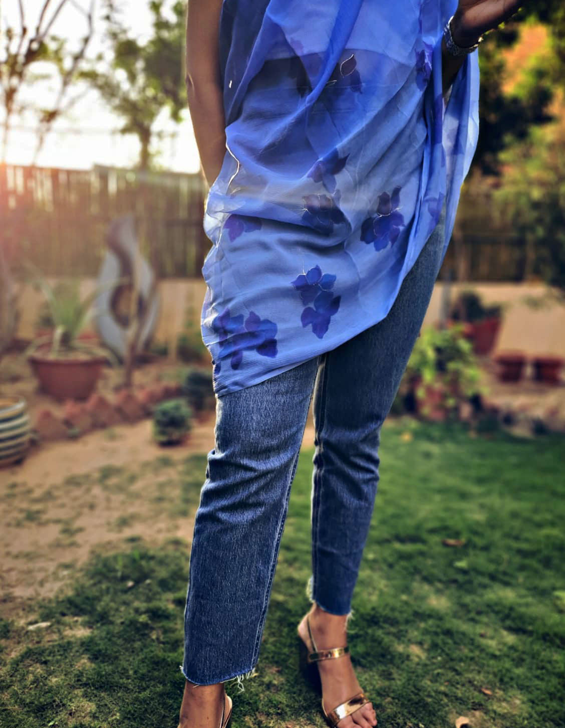 Woman wearing a blue hand painted floral stole in a garden setting