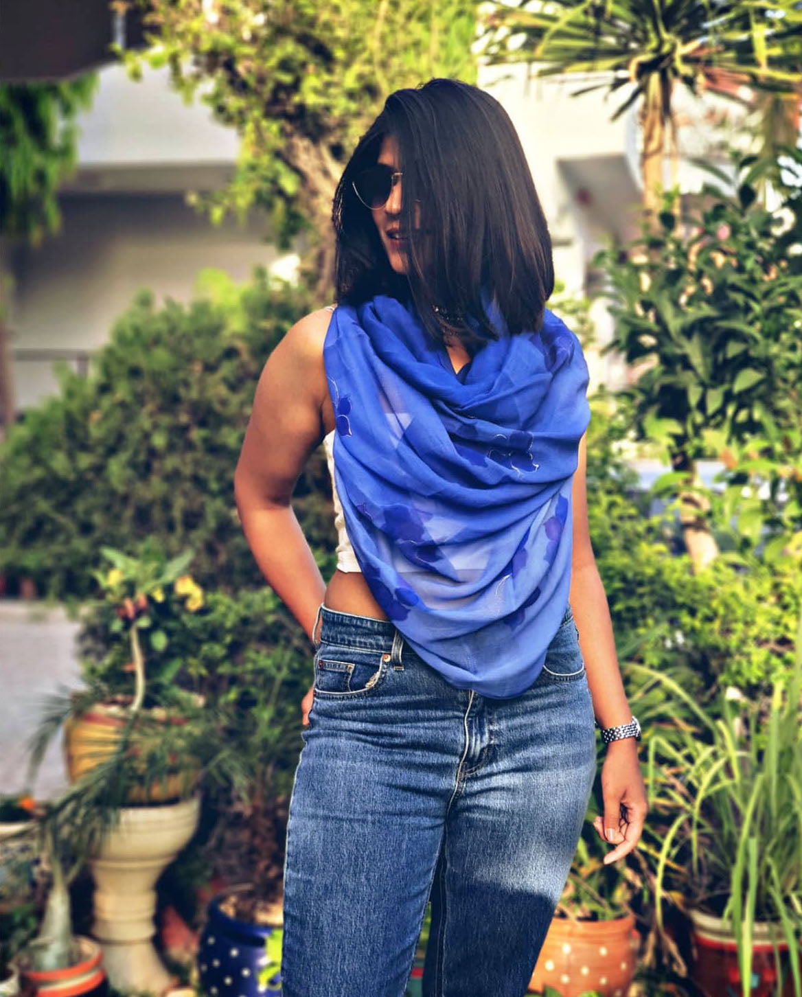 Woman wearing a blue hand painted floral stole in a garden setting