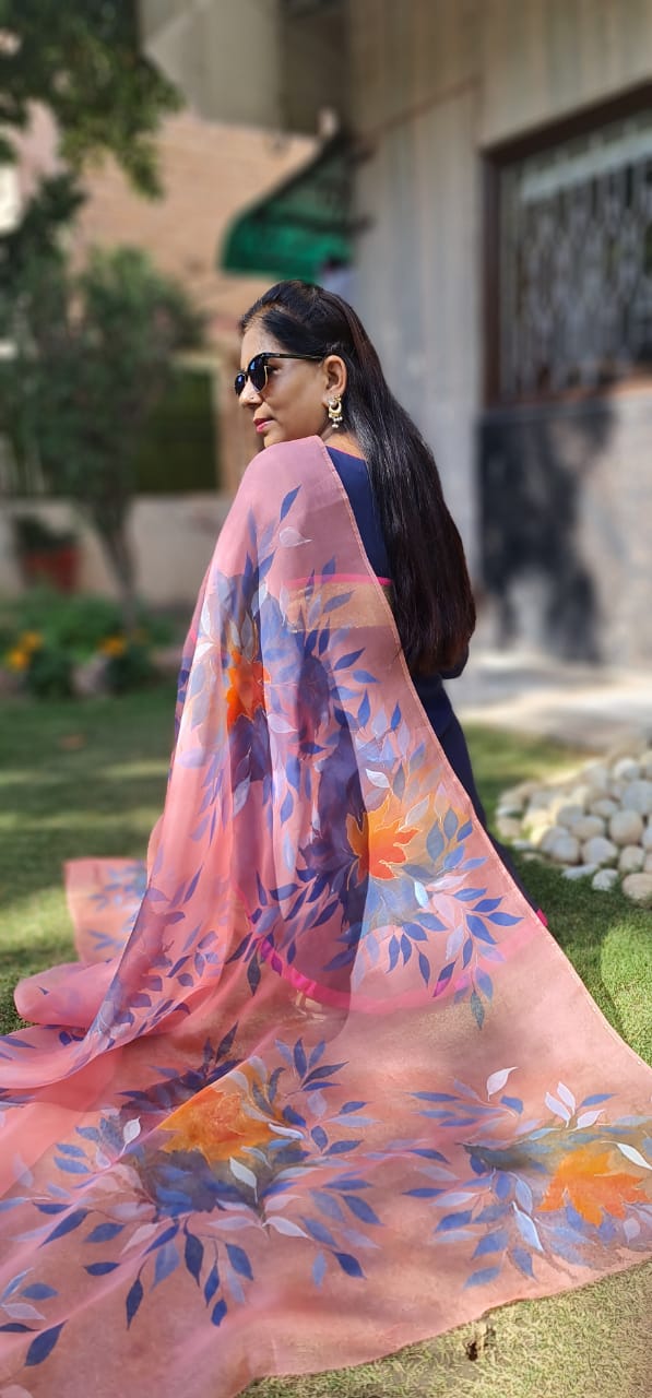 Woman holding a hand painted floral pink dupatta.