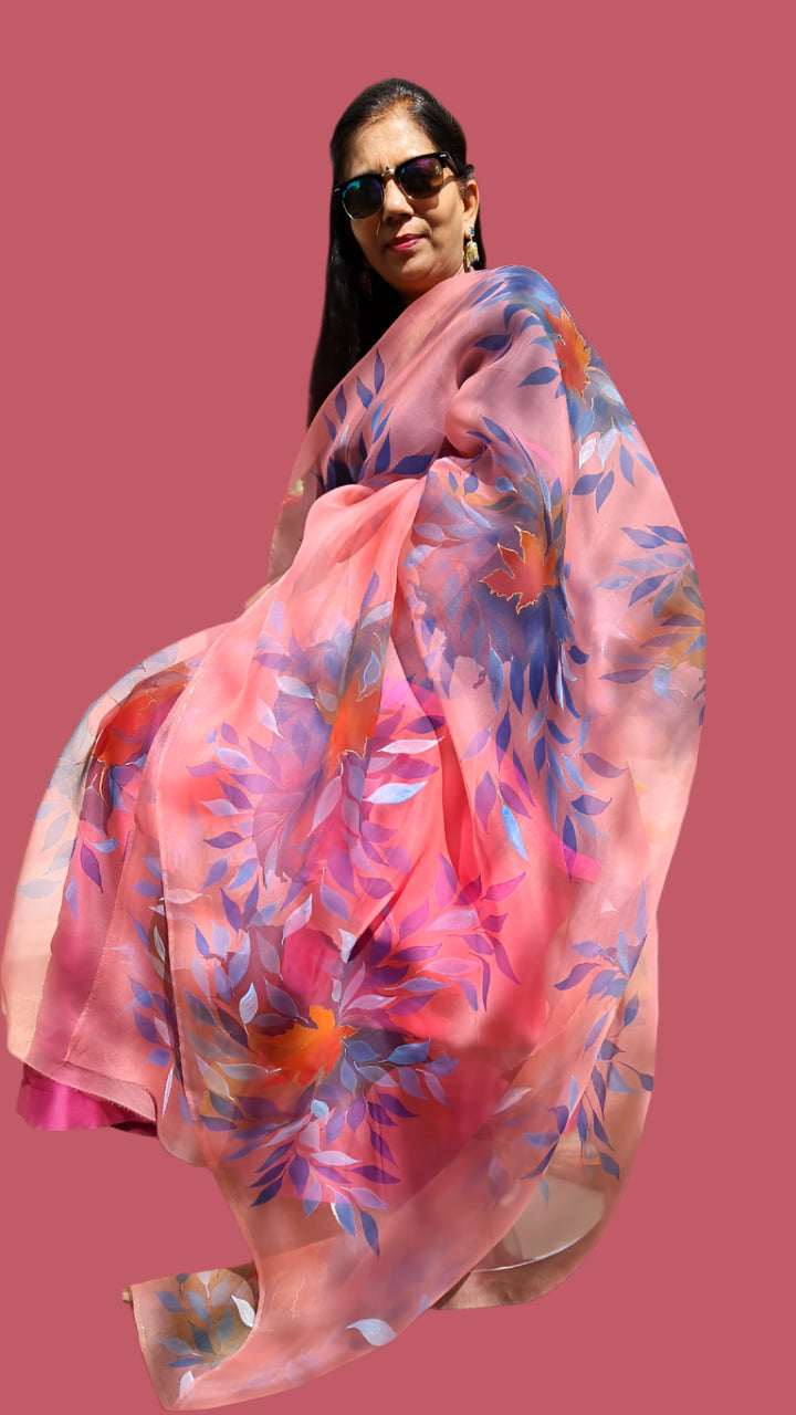 Woman holding a hand painted floral pink dupatta.