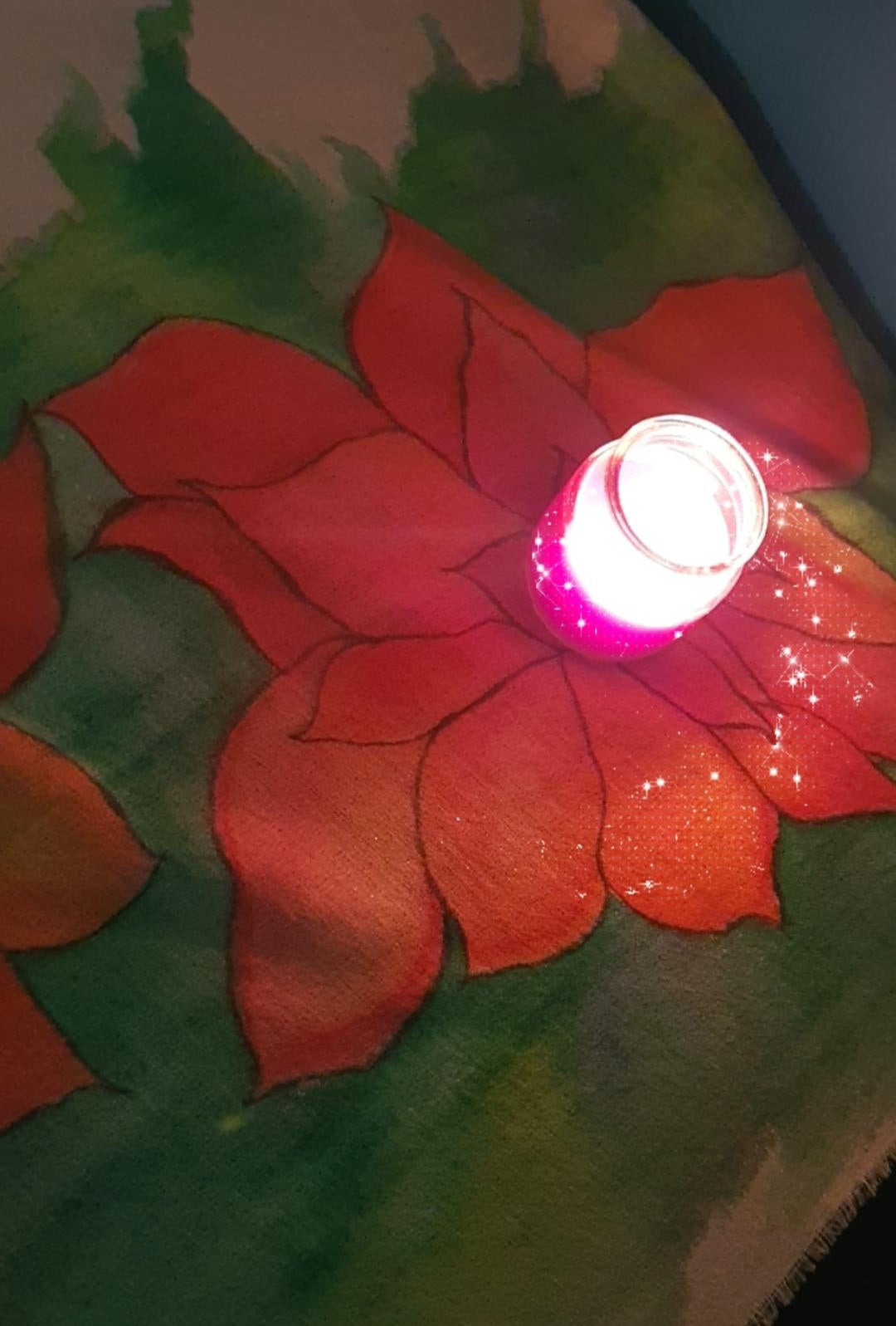 Detailed view of red flower design on a green background with a small light source.
