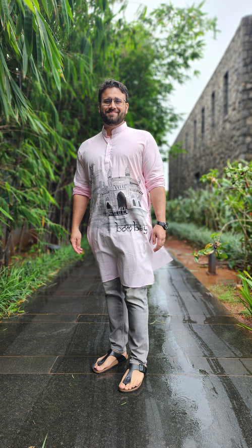 Person standing on a reflective surface with greenery in the background
