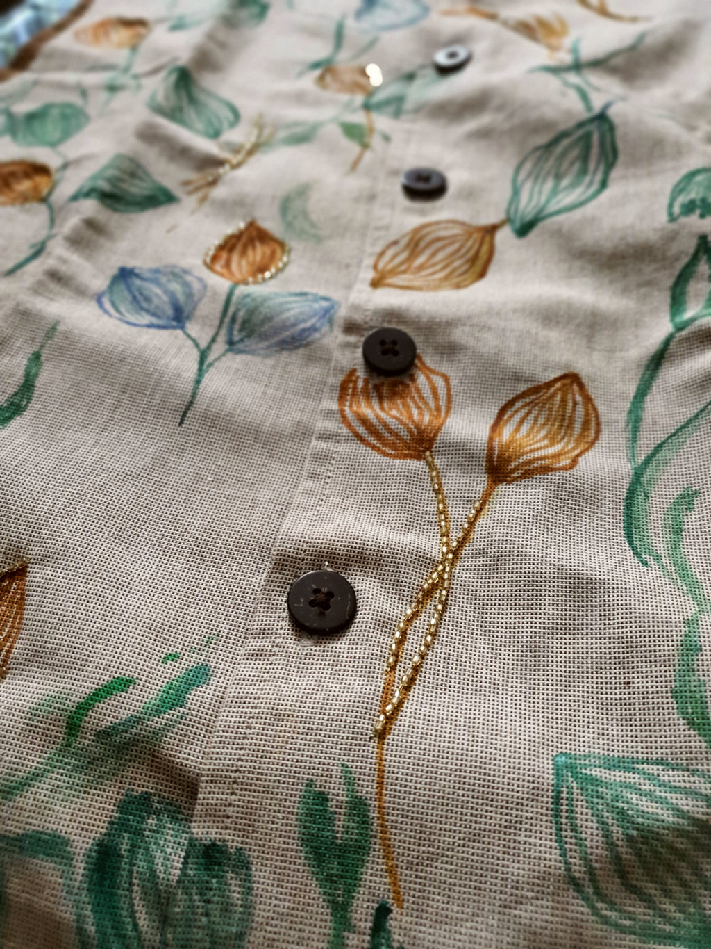Close-up of a fabric with floral embroidery and buttons.