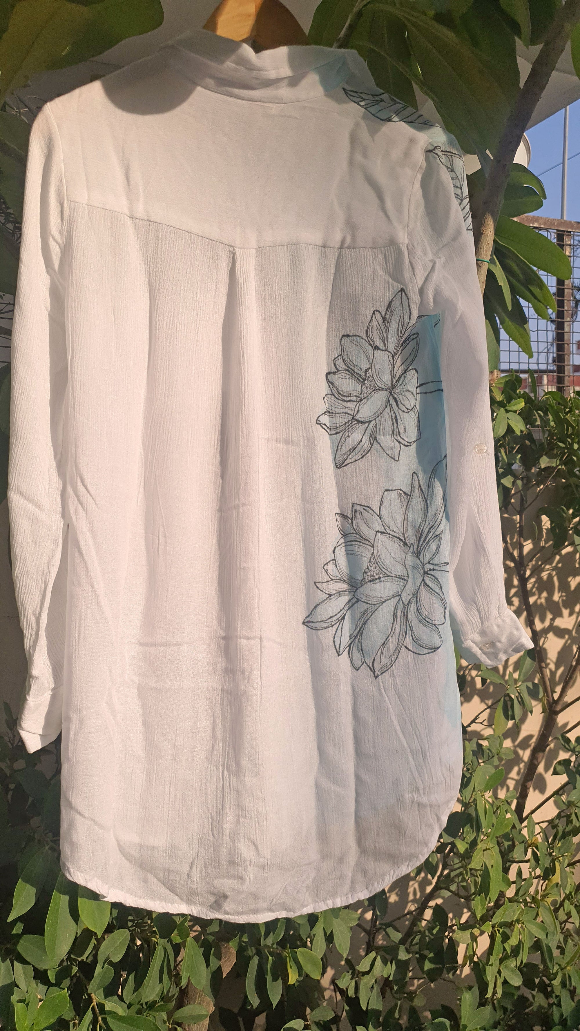White blouse with floral shirt hanging outdoors